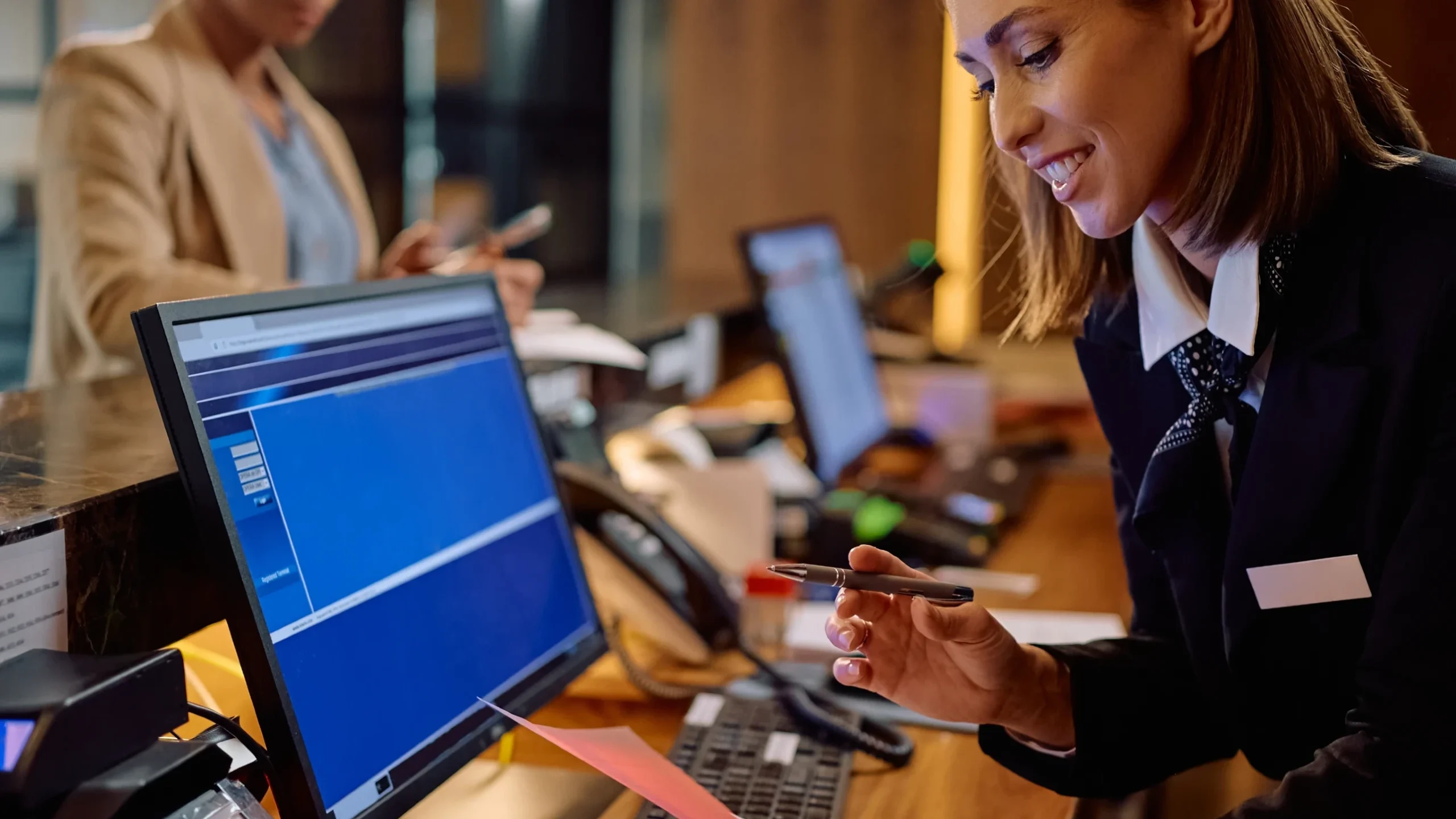 Hotel receptionist managing reservations at the front desk